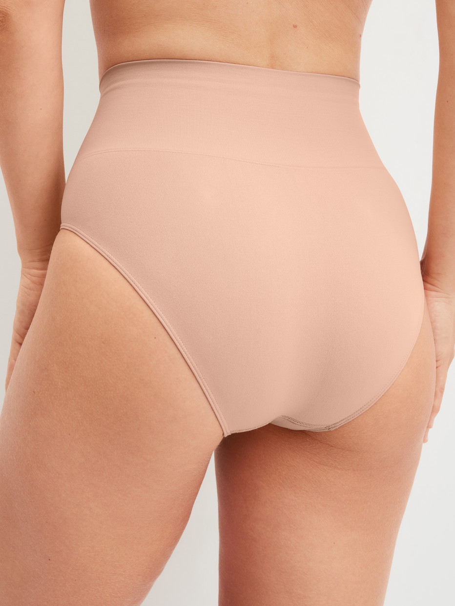 Damen-Model trägt Shaping Slip aus Polyamid in Rosa, Einfarbig aus Serie Seamless Shape von CALIDA, Rückansicht