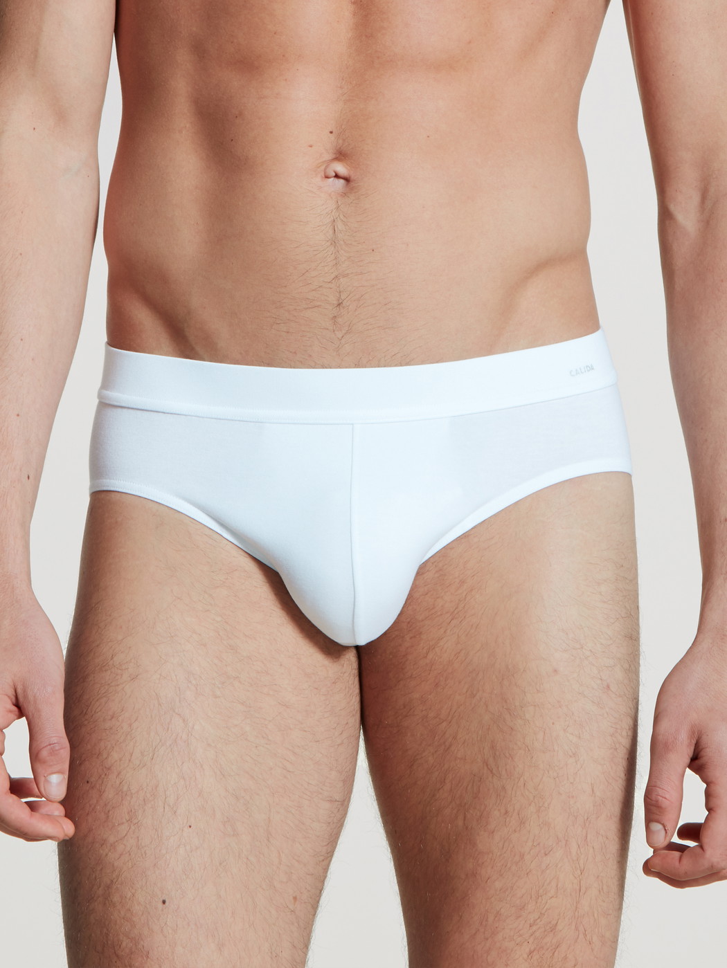 Herren-Model trägt Slip, Komfortbund aus Baumwolle in Weiß, Einfarbig aus Serie Cotton Code von CALIDA, Vorderansicht