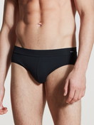 Herren-Model trägt Slip, Komfortbund aus Baumwolle in Schwarz, Einfarbig aus Serie Cotton Code von CALIDA, Vorderansicht