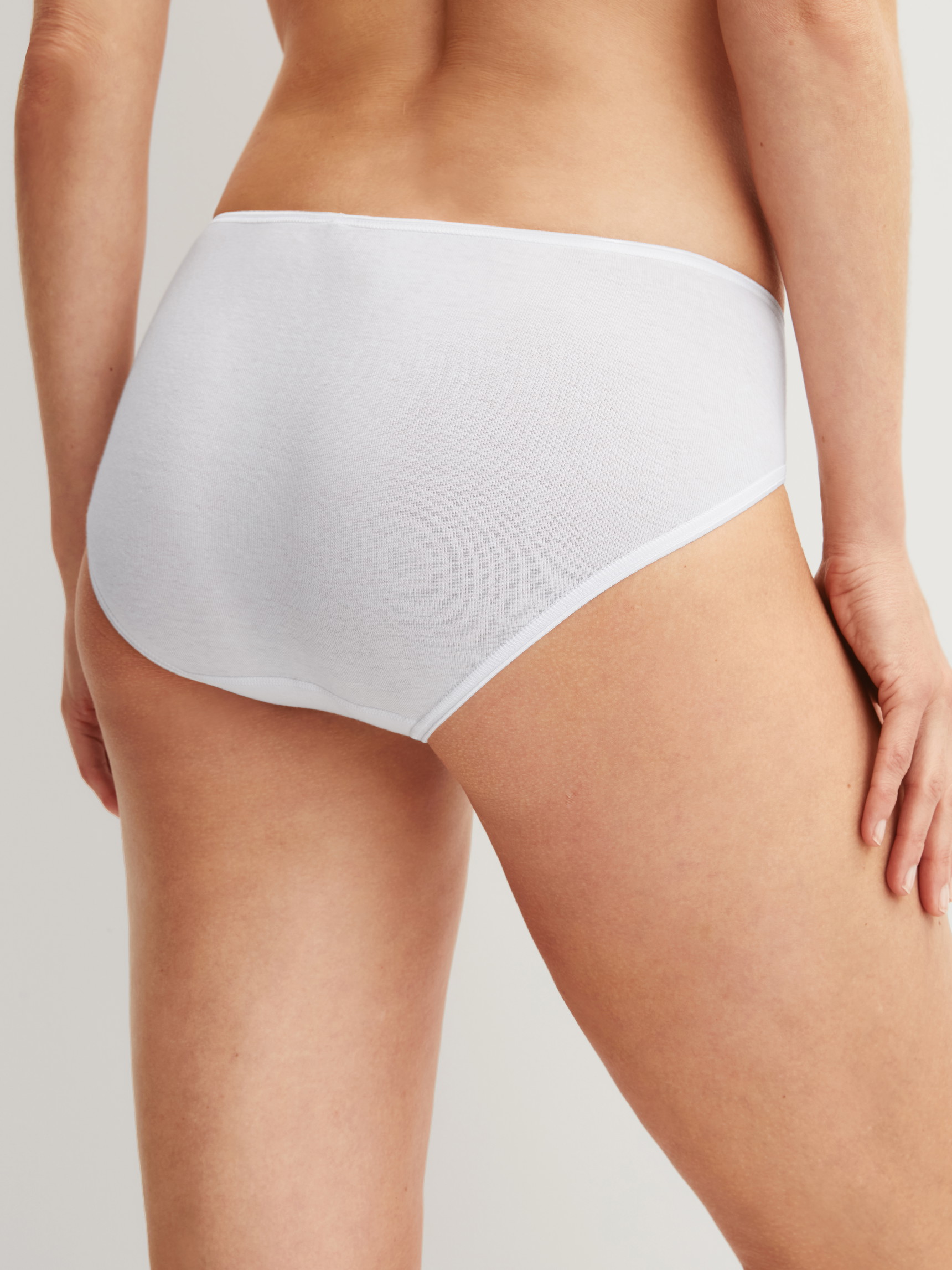 Women model is wearing Mini briefs made of 100% Cotton in White, Lace from the Cotton Desire series by CALIDA, Back view