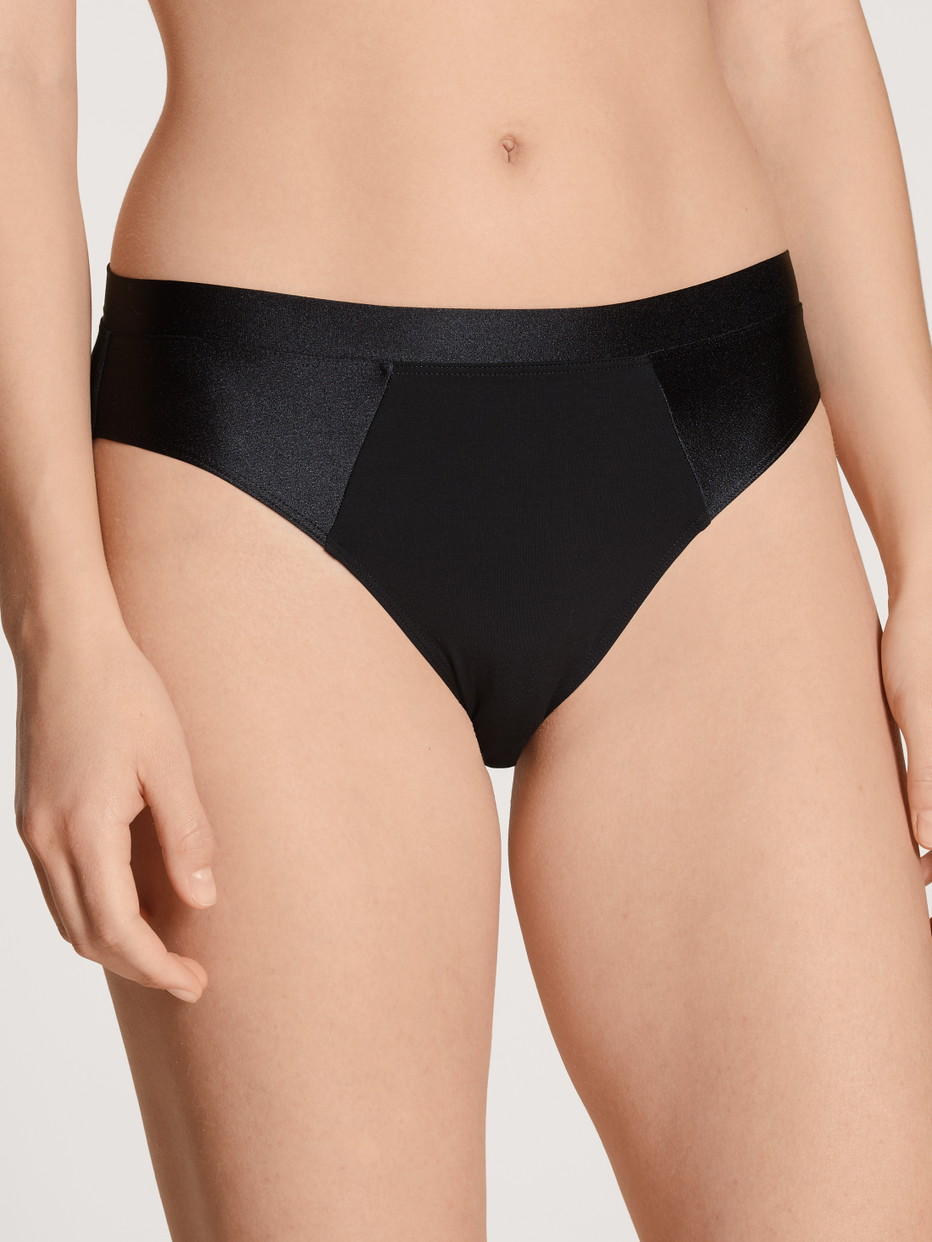 Damen-Model trägt Slip aus Baumwolle in Schwarz, Einfarbig aus Serie Cate von CALIDA, Vorderansicht