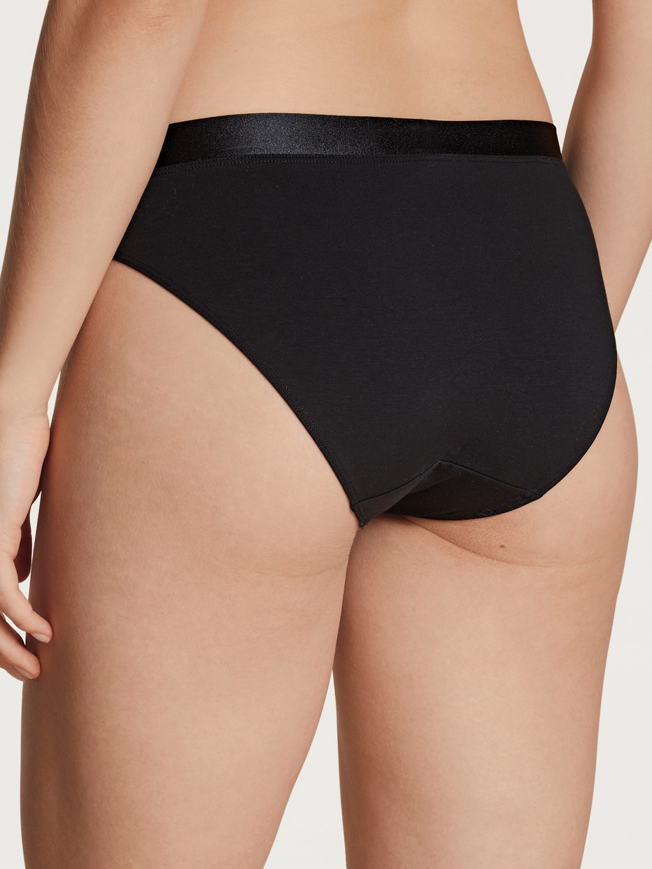 Damen-Model trägt Slip aus Baumwolle in Schwarz, Einfarbig aus Serie Cate von CALIDA, Rückansicht