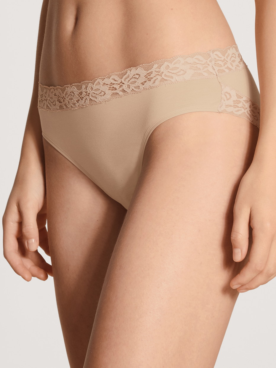 Damen-Model trägt Slip, regular cut aus Baumwolle in Beige, Spitze aus Serie Natural Comfort Lace von CALIDA, Vorderansicht