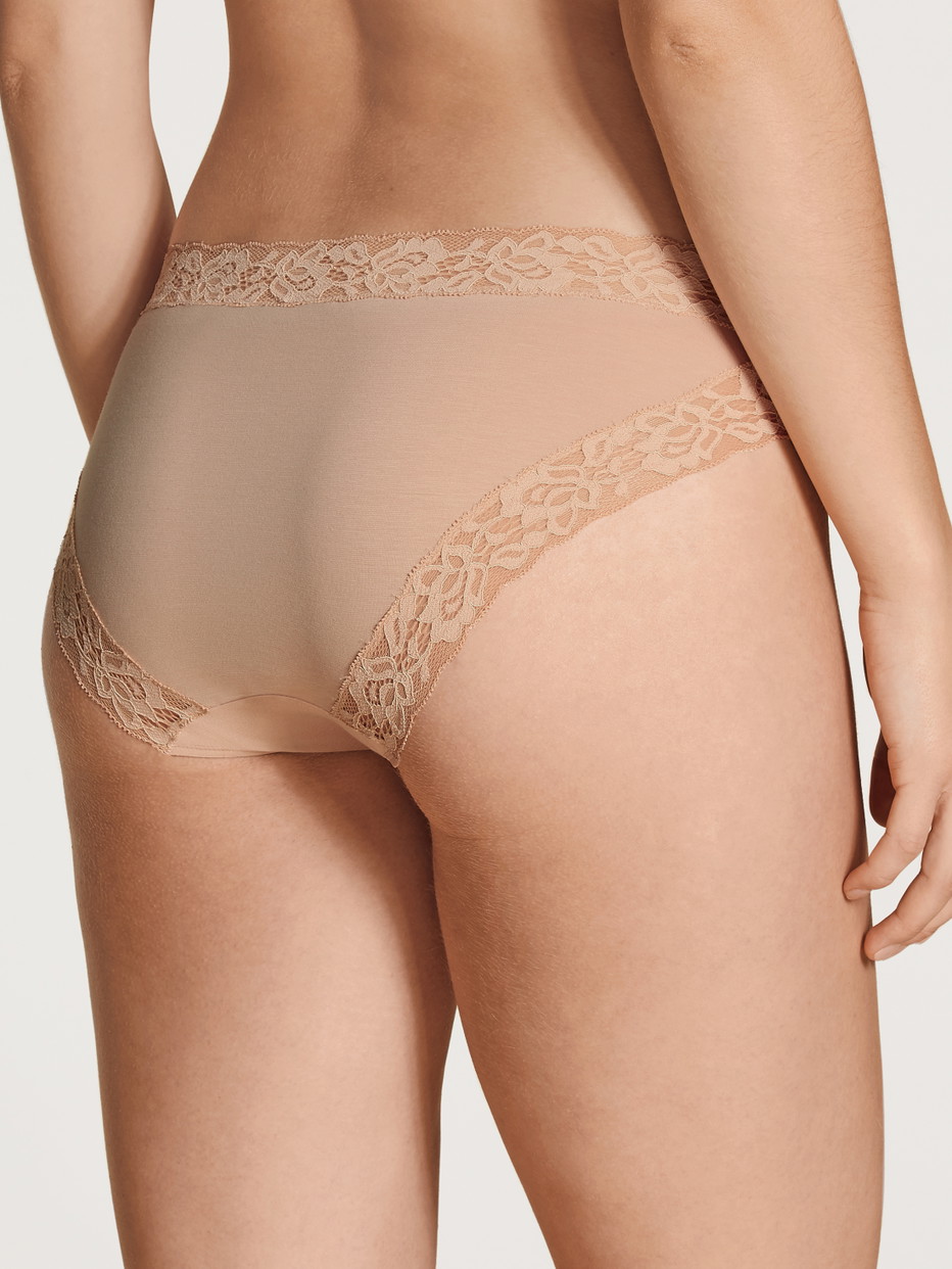 Damen-Model trägt Slip, regular cut aus Baumwolle in Beige, Spitze aus Serie Natural Comfort Lace von CALIDA, Rückansicht
