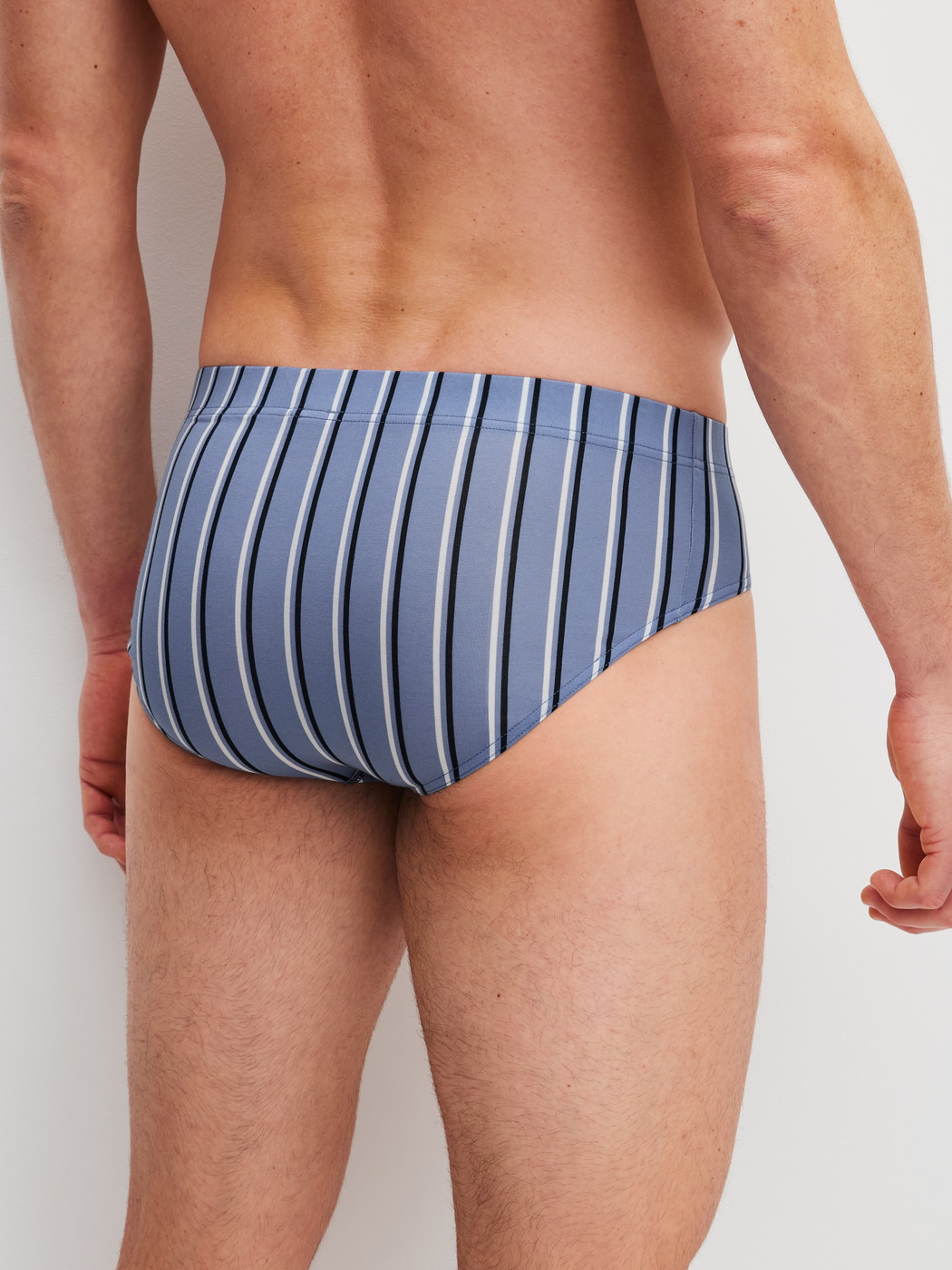 La modella / Il modello Uomo indossa Slip in Pima® Cotone di colore Blu, A righe, della serie Grafic Cotton di CALIDA, Vista posteriore