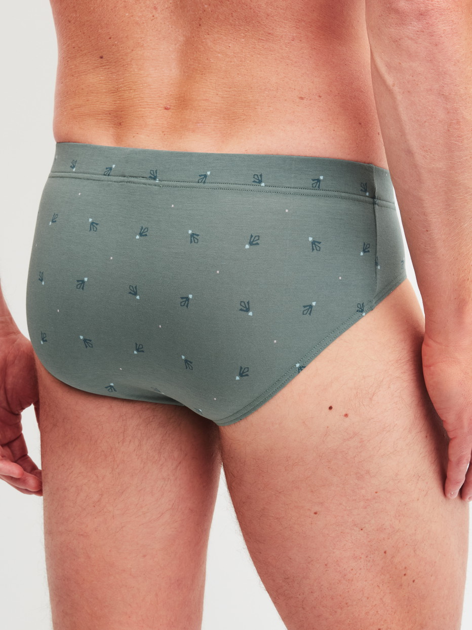 Herren-Model trägt Slip aus Baumwolle in Grün, Gemustert aus Serie Grafic Cotton von CALIDA, Rückansicht