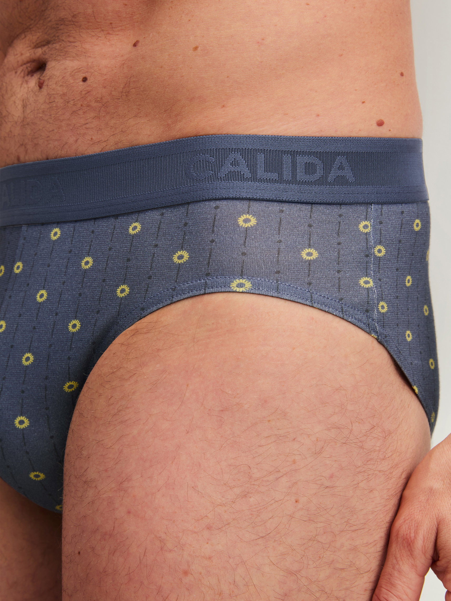 Herren-Model trägt Slip mit Softgummibund aus Baumwolle in Grau, Gemustert aus Serie EDITION 85 von CALIDA, Detail
