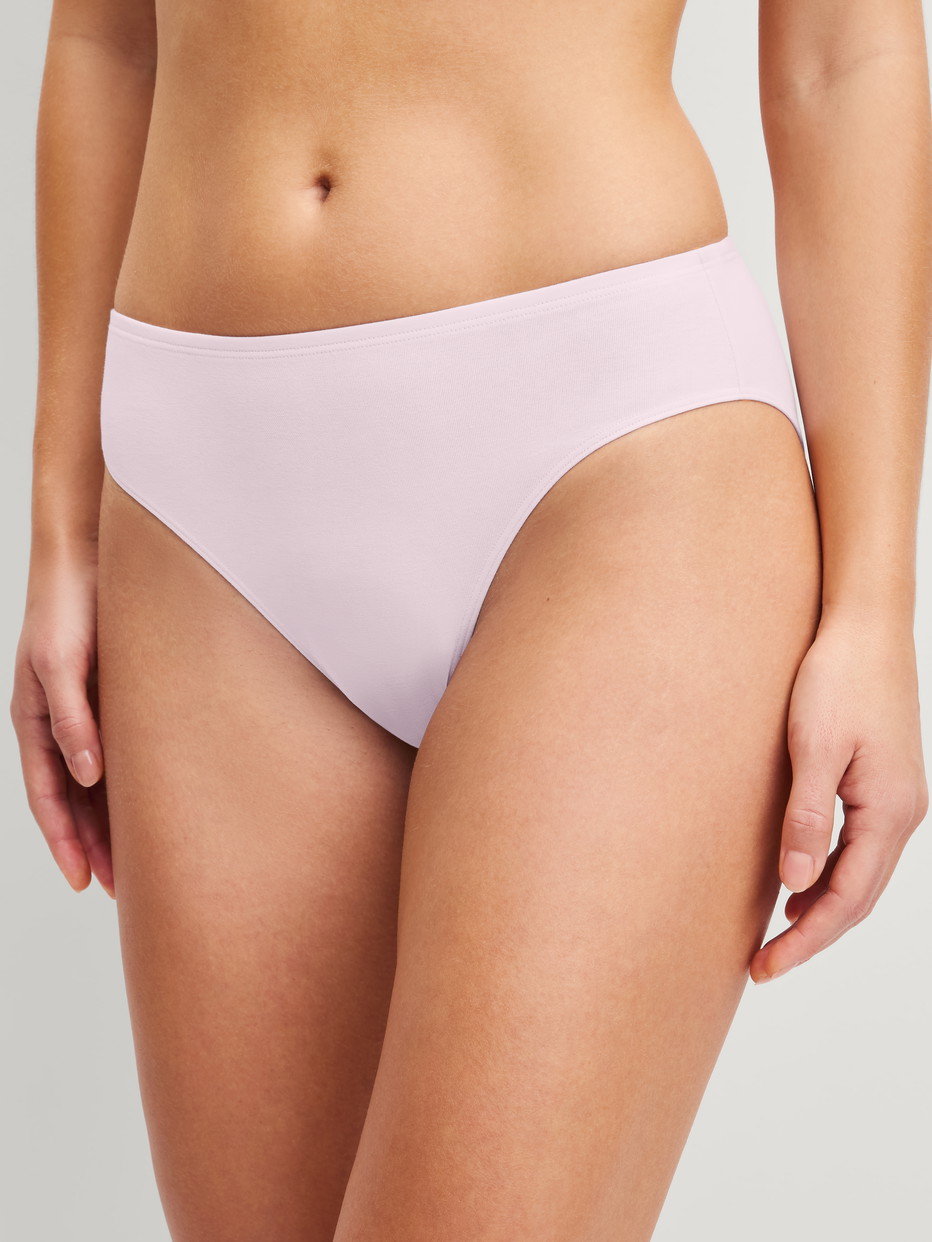 Damen-Model trägt Slip, regular cut aus Baumwolle in Rosa, Einfarbig aus Serie Essential Cotton von CALIDA, Vorderansicht