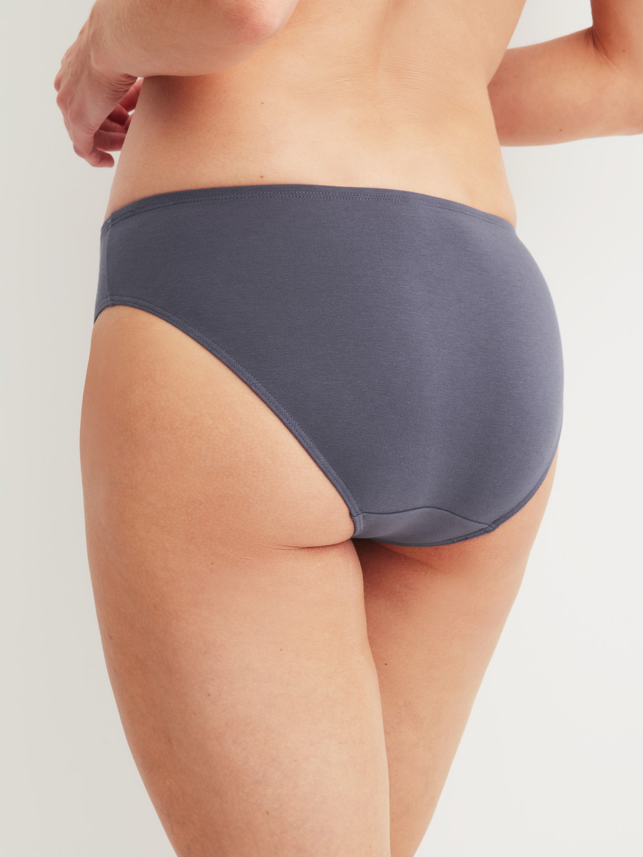 Damen-Model trägt Slip, regular cut aus Baumwolle in Grau, Einfarbig aus Serie Essential Cotton von CALIDA, Rückansicht