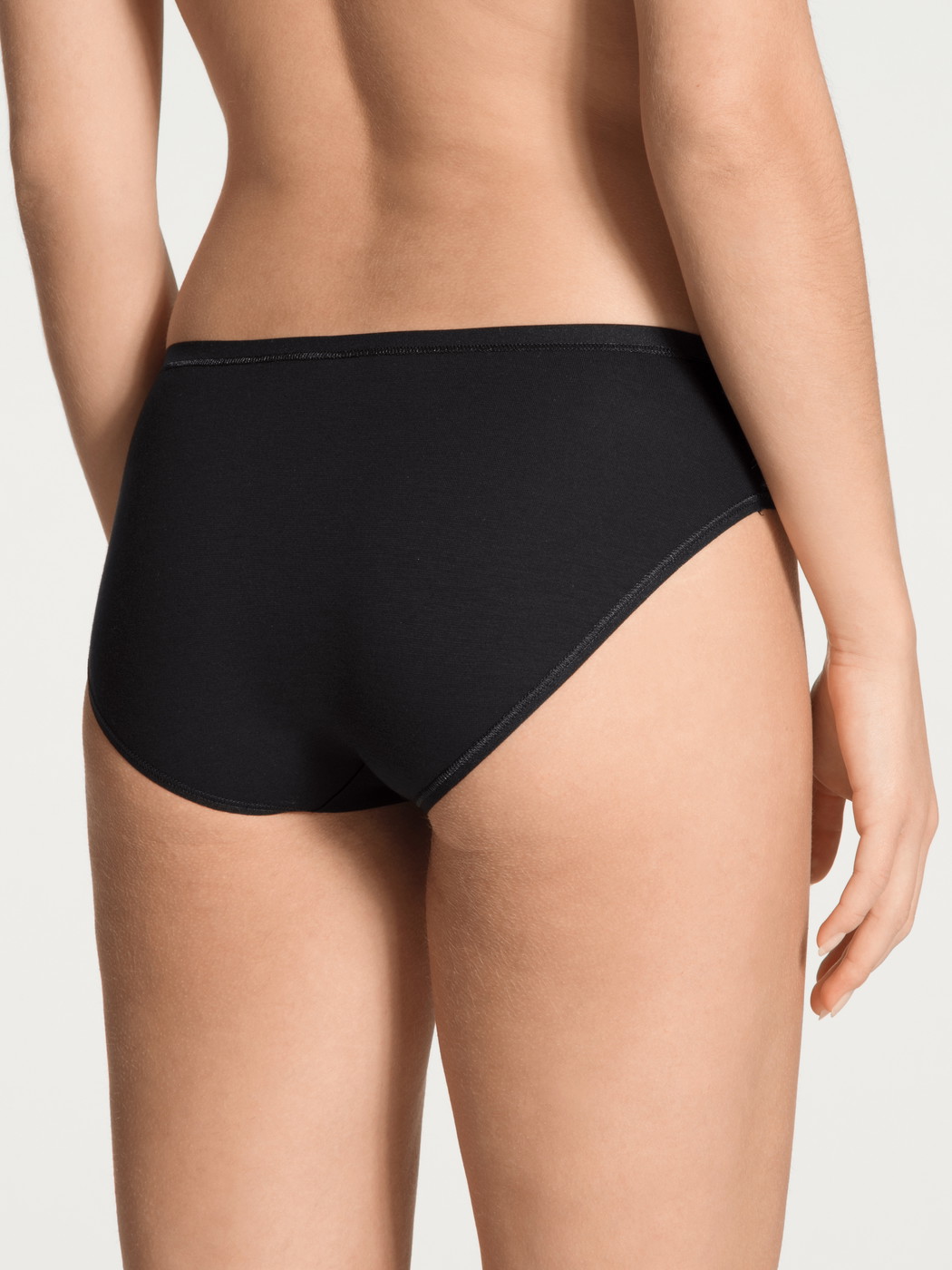 Women model is wearing Brief made of Cotton in Black, Unicoloured from the Benefit Women series by CALIDA, Back view