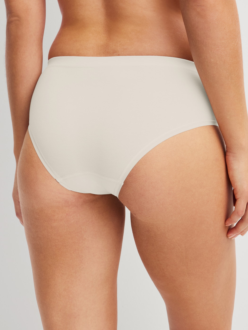 Damen-Model trägt Slip aus Modal in Weiß, Einfarbig aus Serie Seamless Natural von CALIDA, Rückansicht