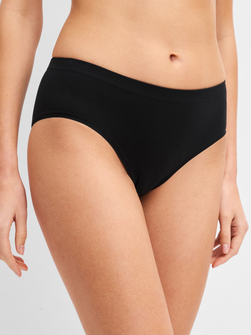 Damen-Model trägt Slip aus Modal in Schwarz, Einfarbig aus Serie Seamless Natural von CALIDA, Vorderansicht