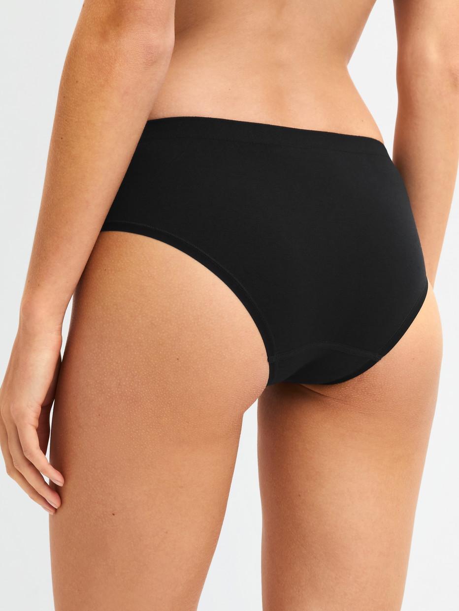 Damen-Model trägt Slip aus Modal in Schwarz, Einfarbig aus Serie Seamless Natural von CALIDA, Rückansicht