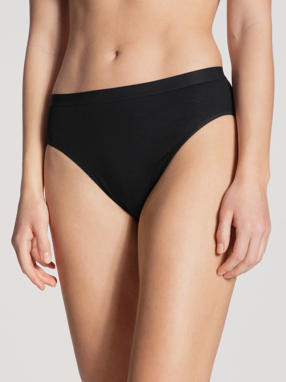 Damen-Model trägt Taillen-Minislip aus 100% Baumwolle in Schwarz, Einfarbig aus Serie Light von CALIDA, Vorderansicht