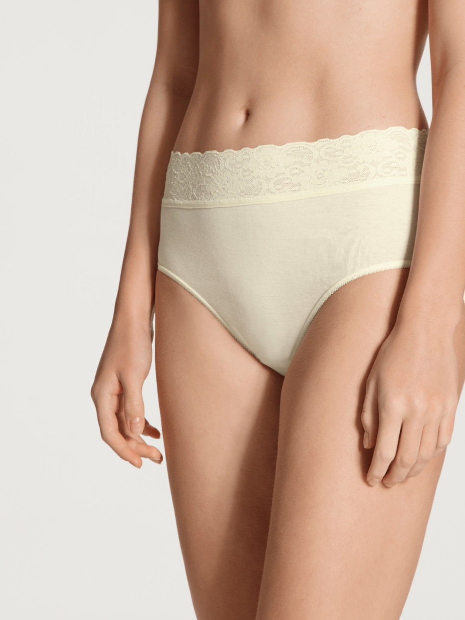 Damen-Model trägt Midi-Slip aus 100% Baumwolle in Beige, Spitze aus Serie Iconics von CALIDA, Vorderansicht