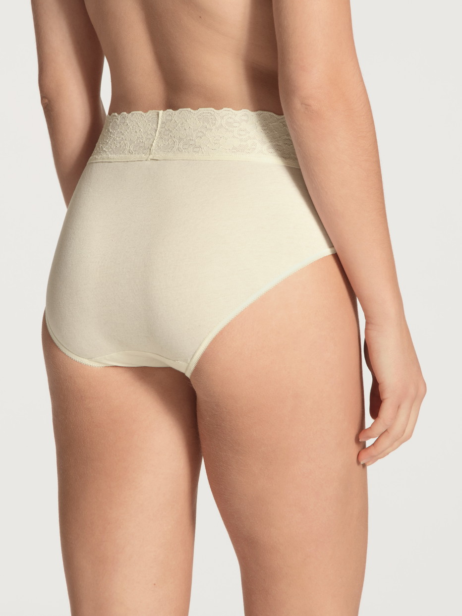 Damen-Model trägt Midi-Slip aus 100% Baumwolle in Beige, Spitze aus Serie Iconics von CALIDA, Rückansicht