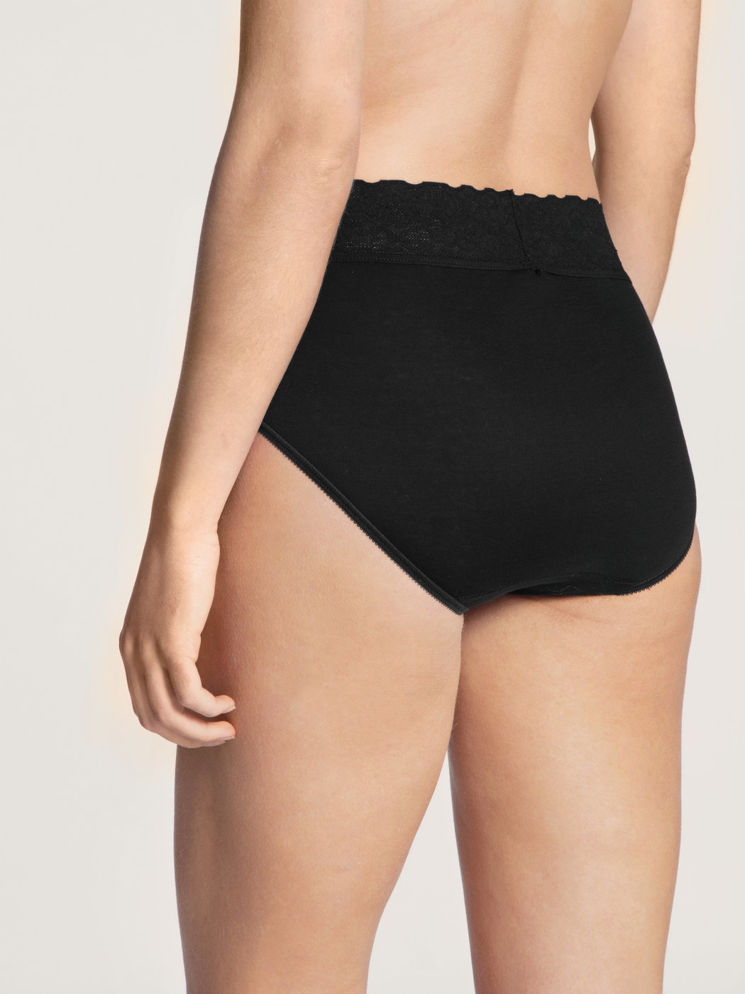 Le mannequin Femme porte le/la Culotte taille haute en 100% coton de couleur Noir, Dentelle, de la série Iconics de CALIDA, Vue arrière