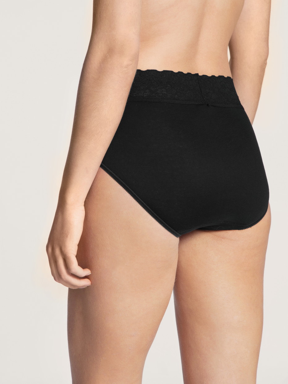 Damen-Model trägt Midi-Slip aus 100% Baumwolle in Schwarz, Spitze aus Serie Iconics von CALIDA, Rückansicht