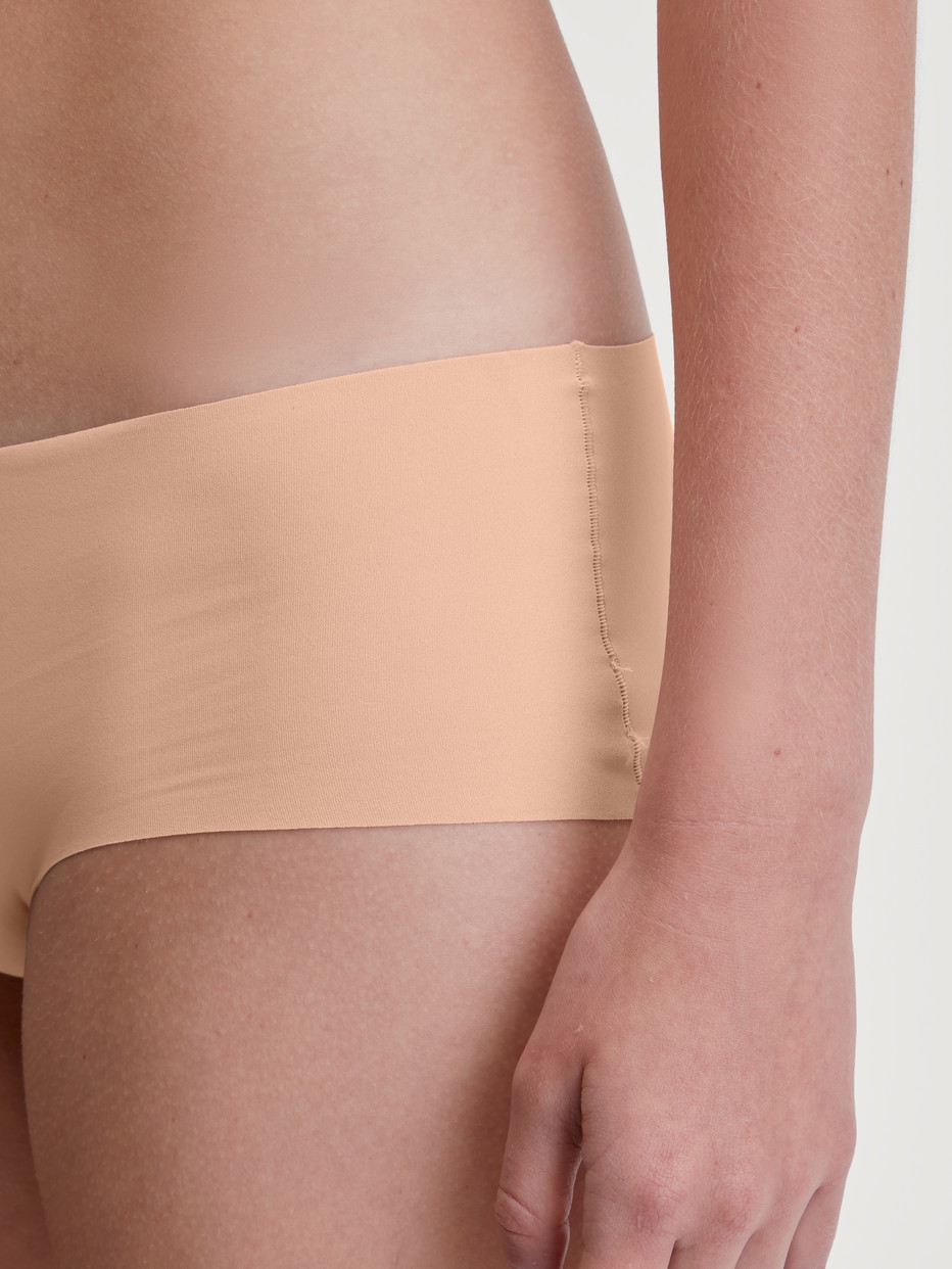 Damen-Model trägt Nahtlose Hipster-Panty Clean-Cut aus Polyamid in Beige, Einfarbig aus Serie Sleek Skin von CALIDA, Detail