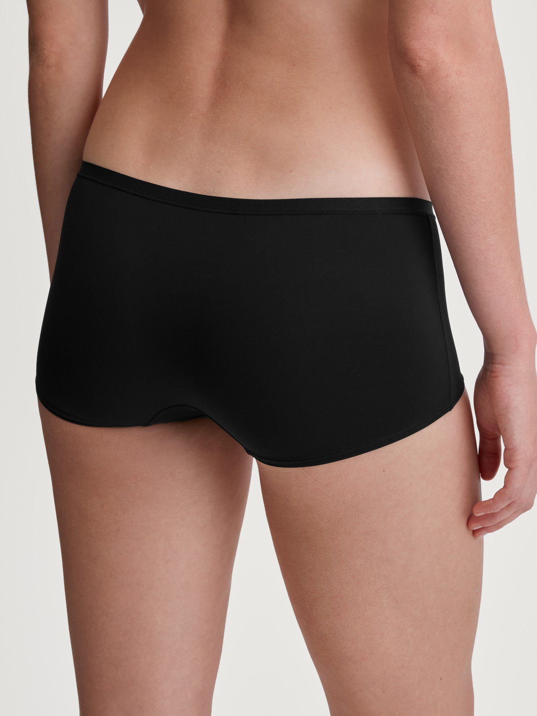 Women model is wearing Shorty regular cut made of Polyamide in Black, Unicoloured from the Sleek Skin series by CALIDA, Back view