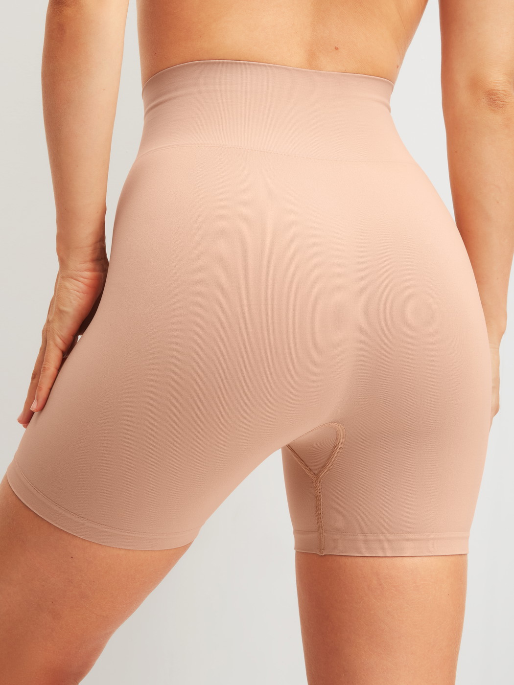 La modella / Il modello Donna indossa Pantaloncino modellante in Poliammide di colore Rosa, Tinta unita, della serie Seamless Shape di CALIDA, Vista posteriore