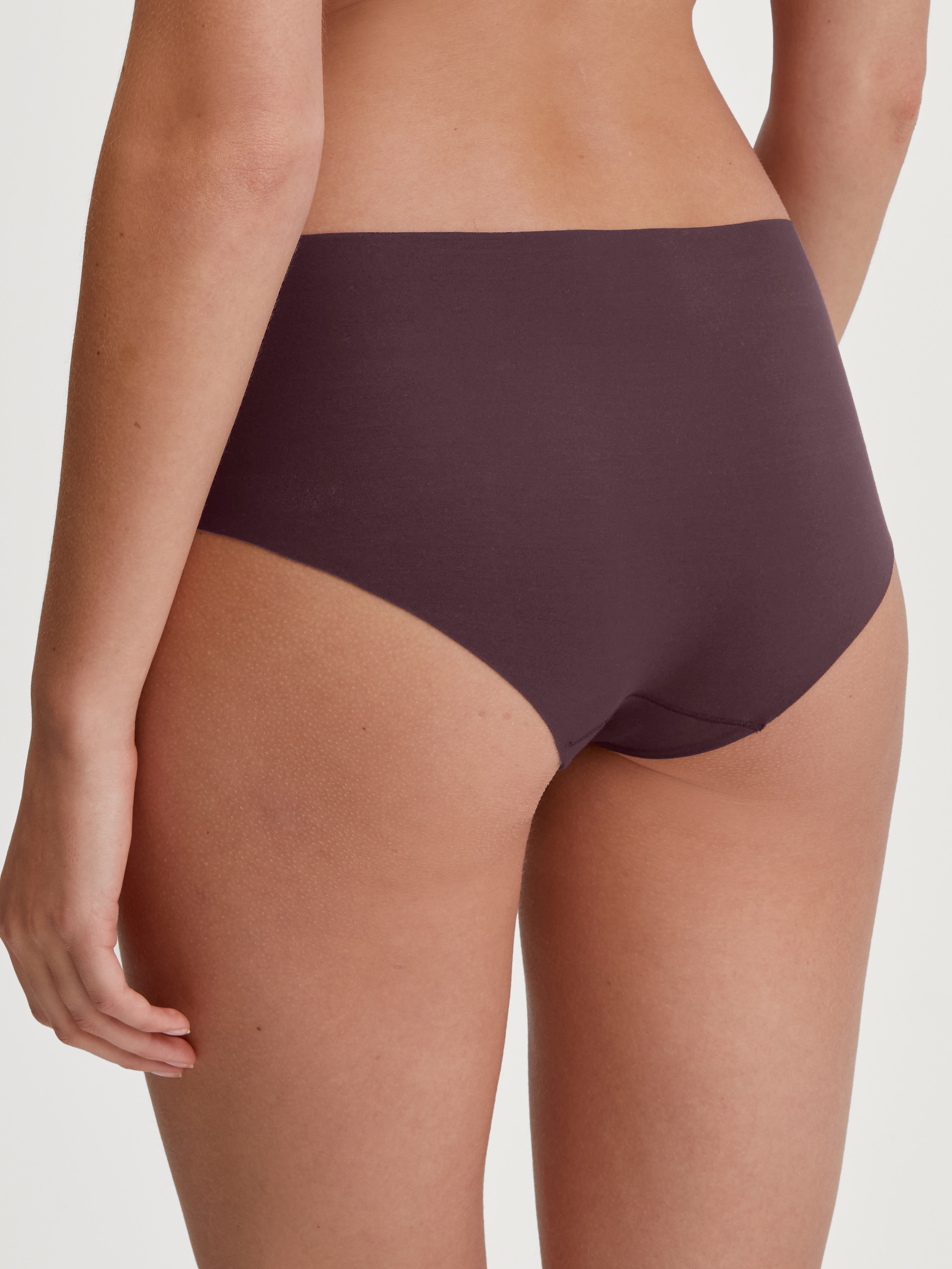 Damen-Model trägt Seamless-Panty, low cut aus Modal in Rot, Einfarbig aus Serie Natural Skin von CALIDA, Rückansicht