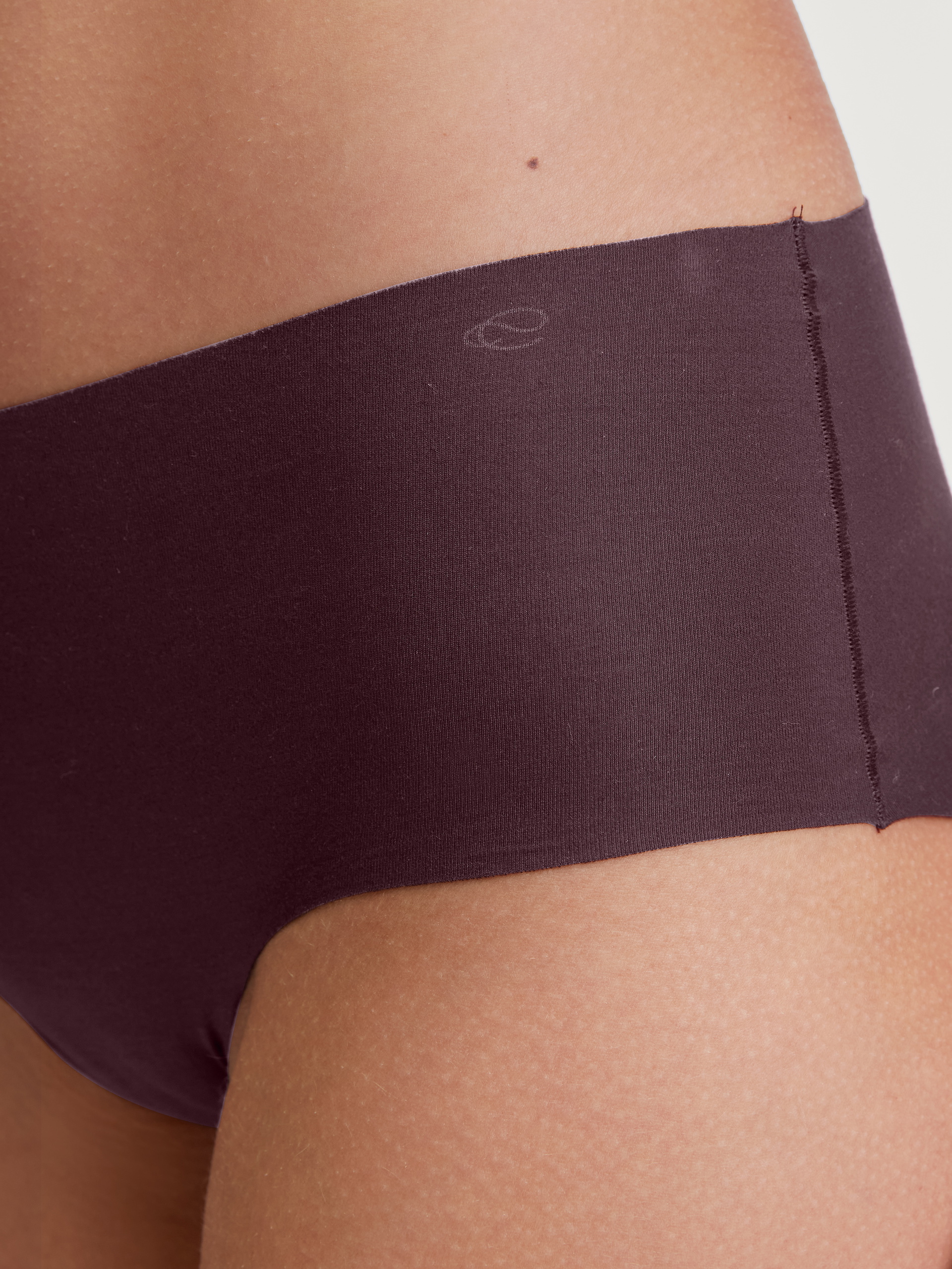 Damen-Model trägt Seamless-Panty, low cut aus Modal in Rot, Einfarbig aus Serie Natural Skin von CALIDA, Detail