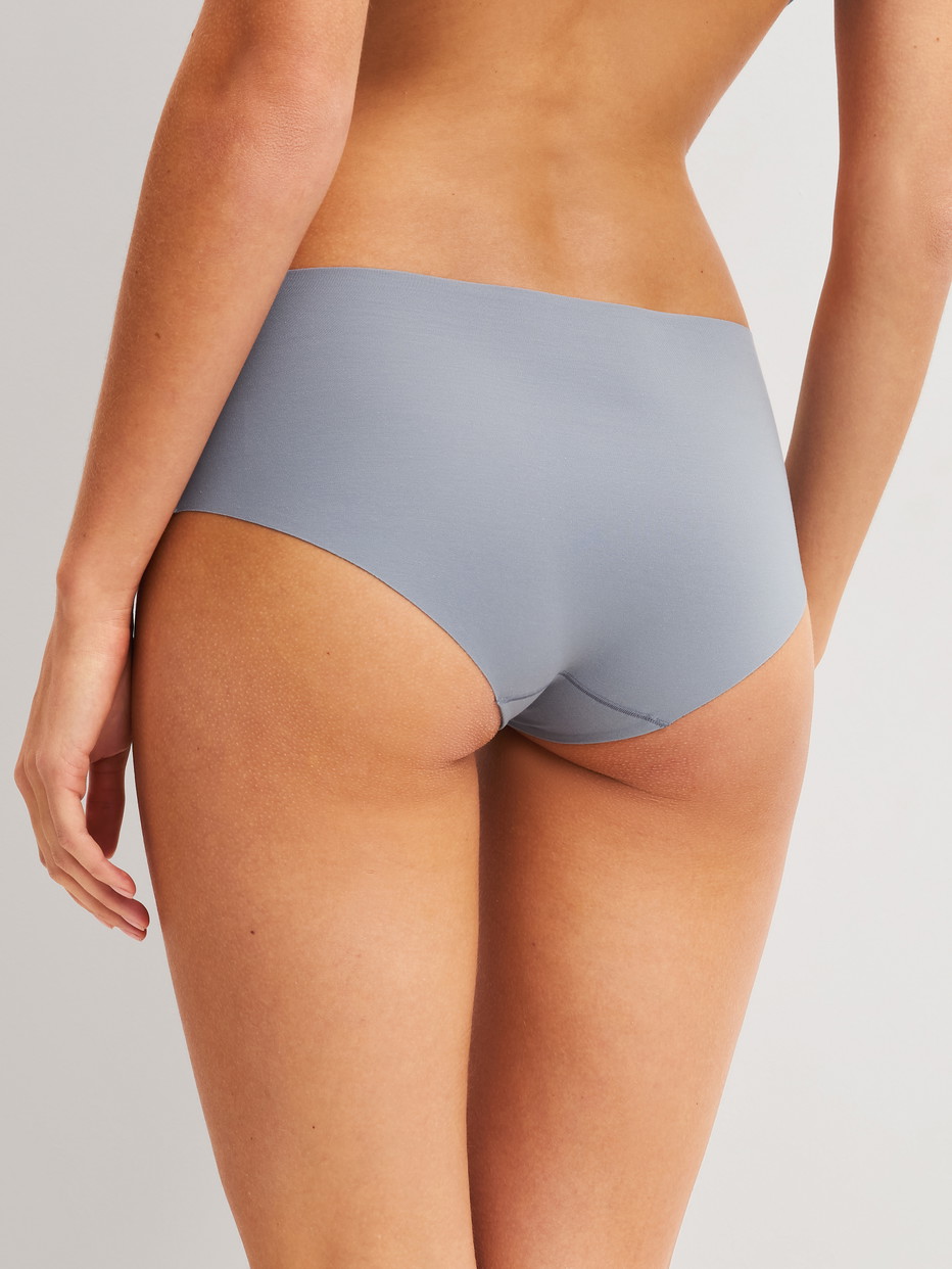Damen-Model trägt Seamless-Panty, low cut aus Modal in Grau, Einfarbig aus Serie Natural Skin von CALIDA, Rückansicht