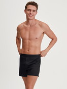 Le mannequin Homme porte le/la Boxer short en TENCEL™ de couleur Noir, Unicolore, de la série Natural Cooling de CALIDA, Tenue