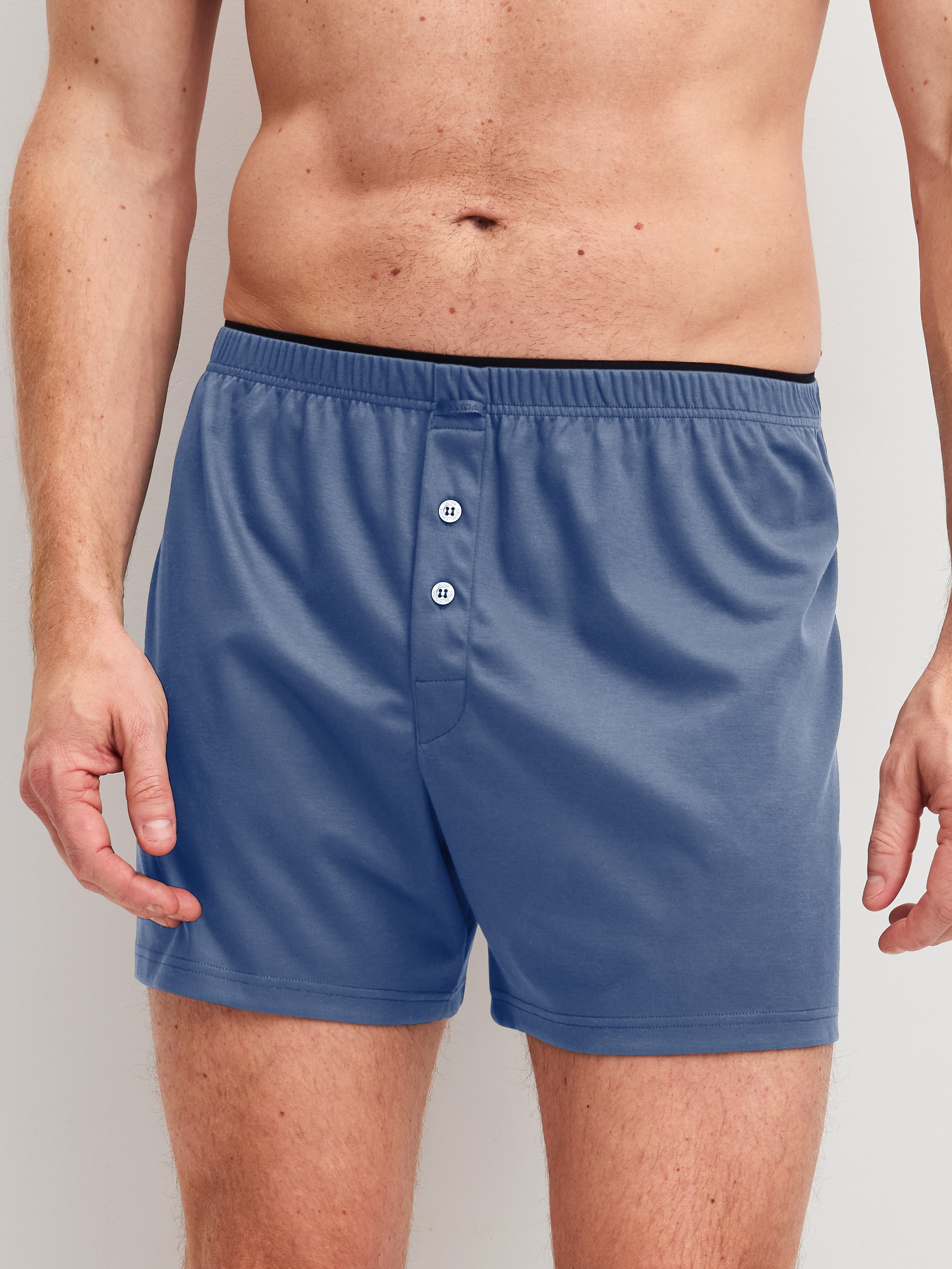 Herren-Model trägt Boxershorts aus 100% Baumwolle in Blau, Einfarbig aus Serie Cotton Choice von CALIDA, Vorderansicht