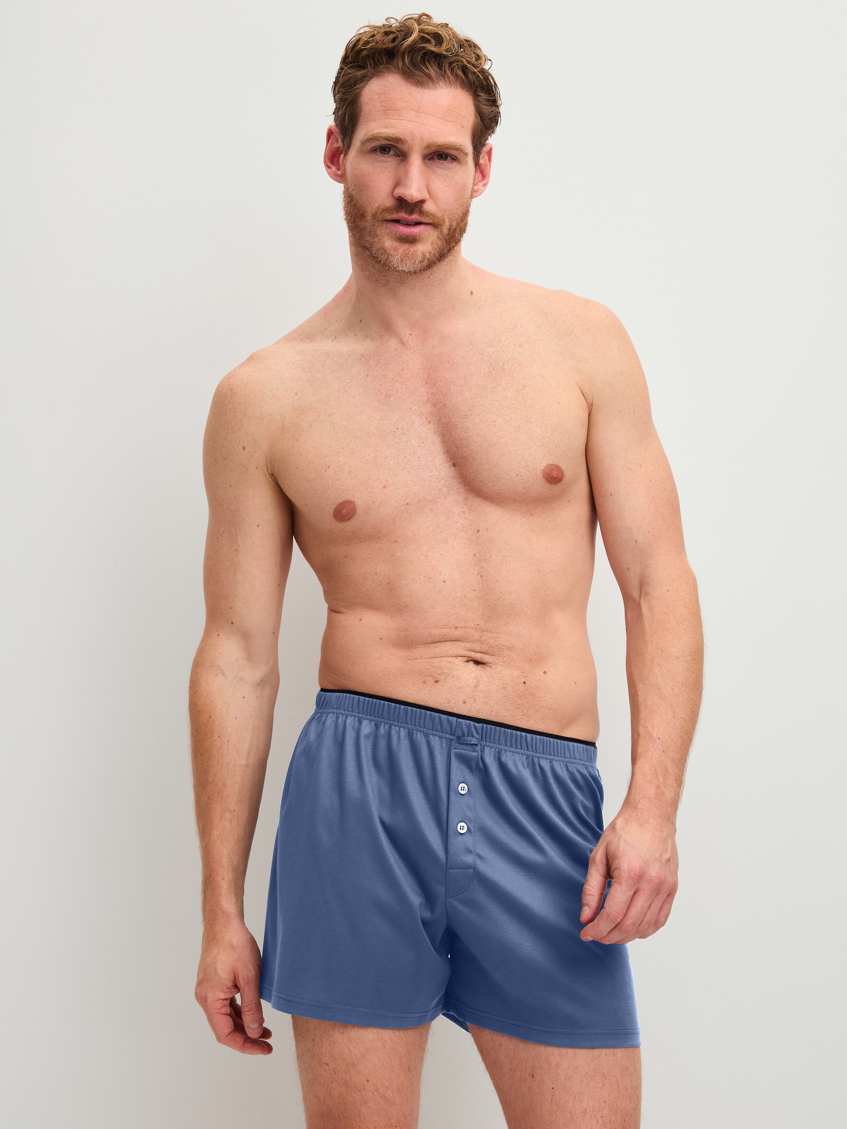 Herren-Model trägt Boxershorts aus 100% Baumwolle in Blau, Einfarbig aus Serie Cotton Choice von CALIDA, Vorderansicht