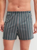 La modella / Il modello Uomo indossa Boxer short in Cotone di colore Blu, Modello, della serie Prints di CALIDA, Vista frontale