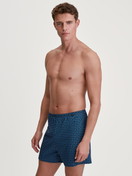 Le mannequin Homme porte le/la Boxer short en 100% coton de couleur Bleu, À motifs, de la série Prints de CALIDA, Tenue