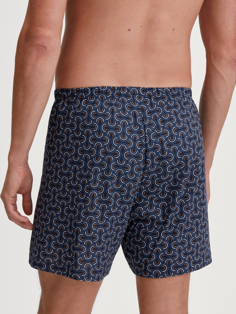 La modella / Il modello Uomo indossa Boxer short in 100% cotone di colore Blu, Modello, della serie Prints di CALIDA, Vista posteriore