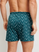 Men model is wearing Boxer shorts made of 100% Cotton in Turquoise, Patterned from the Prints series by CALIDA, Back view