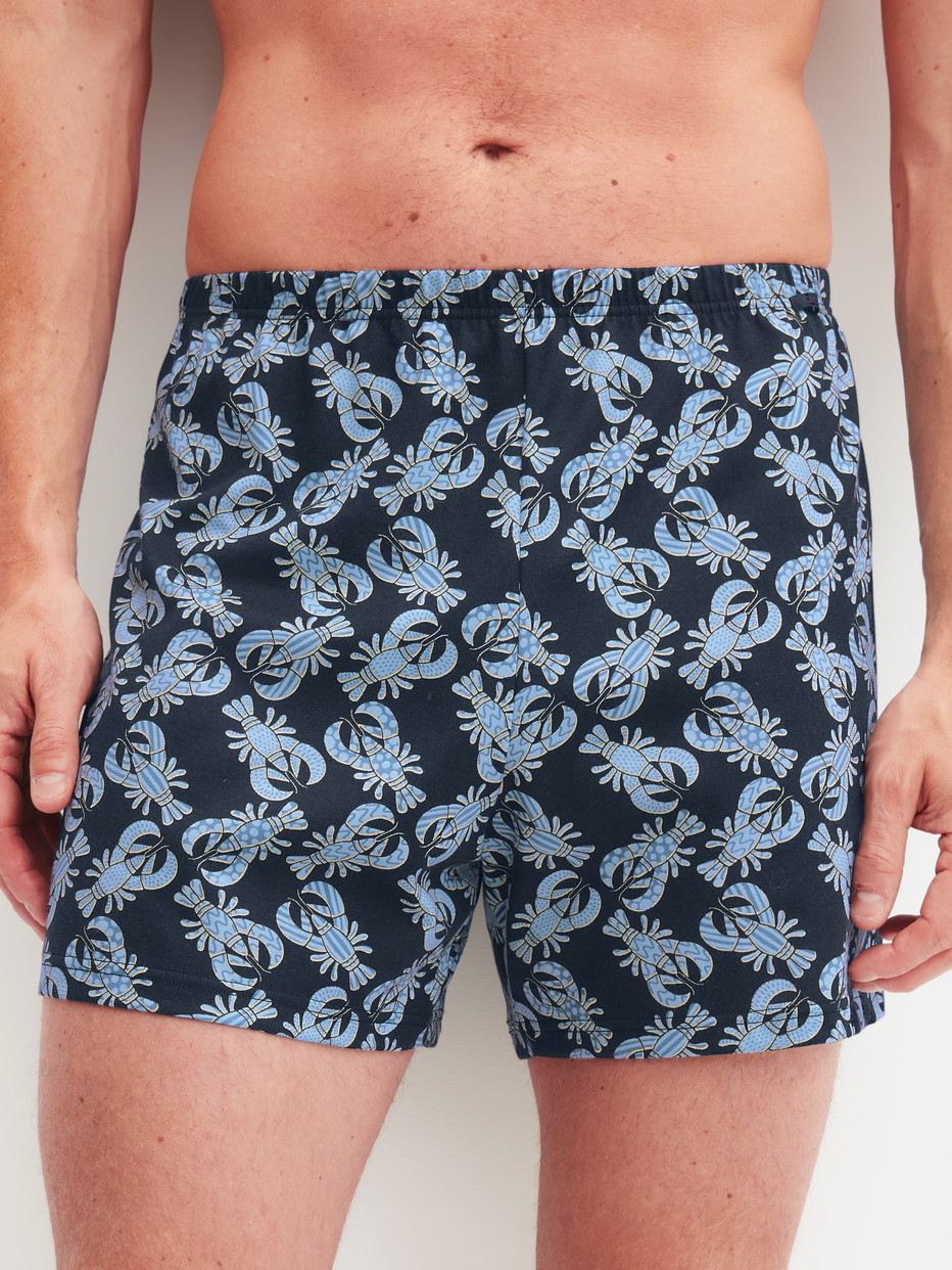 Herren-Model trägt Jersey-Boxershorts ohne Eingriff aus Baumwolle in Blau, Gemustert aus Serie Prints von CALIDA, Vorderansicht