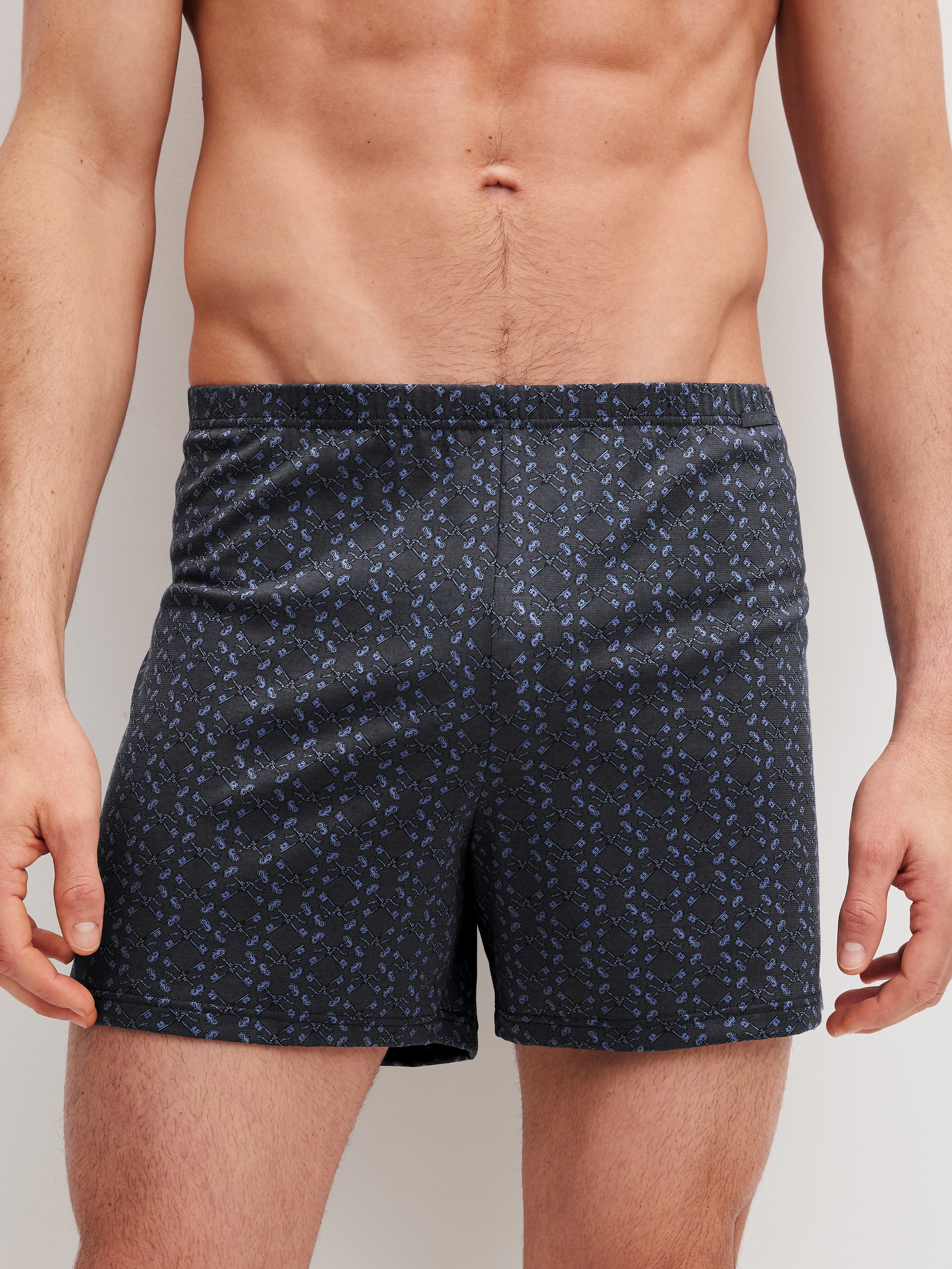 Herren-Model trägt Jersey-Boxershorts ohne Eingriff aus 100% Baumwolle in Grau, Gemustert aus Serie Prints von CALIDA, Vorderansicht
