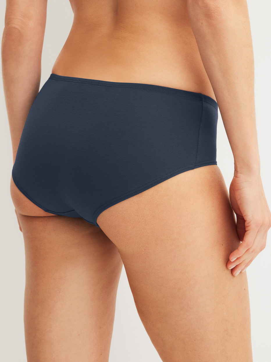 La modella / Il modello Donna indossa Panty a vita bassa in Cotone di colore Blu, Tinta unita, della serie Essential Cotton Spe di CALIDA, Vista posteriore