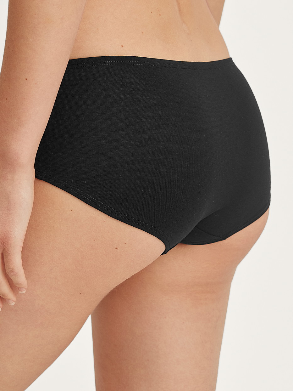 Damen-Model trägt Panty, low cut aus Baumwolle in Schwarz, Einfarbig aus Serie Essential Cotton von CALIDA, Rückansicht