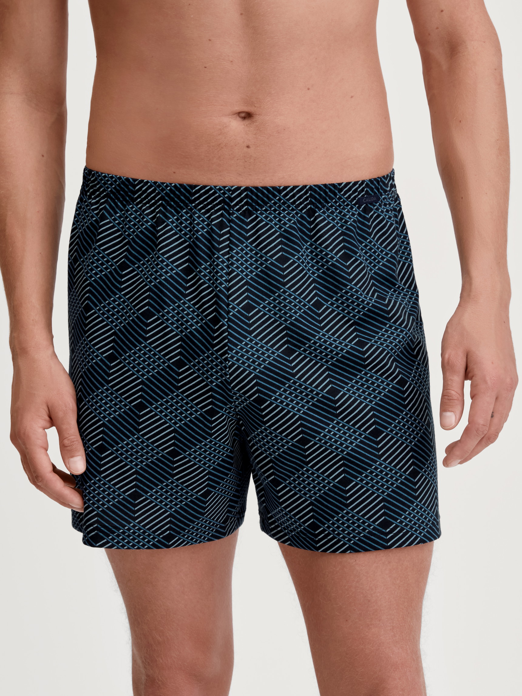 Men model is wearing Boxer shorts made of 100% Cotton in Black, Patterned from the Prints series by CALIDA, Front view