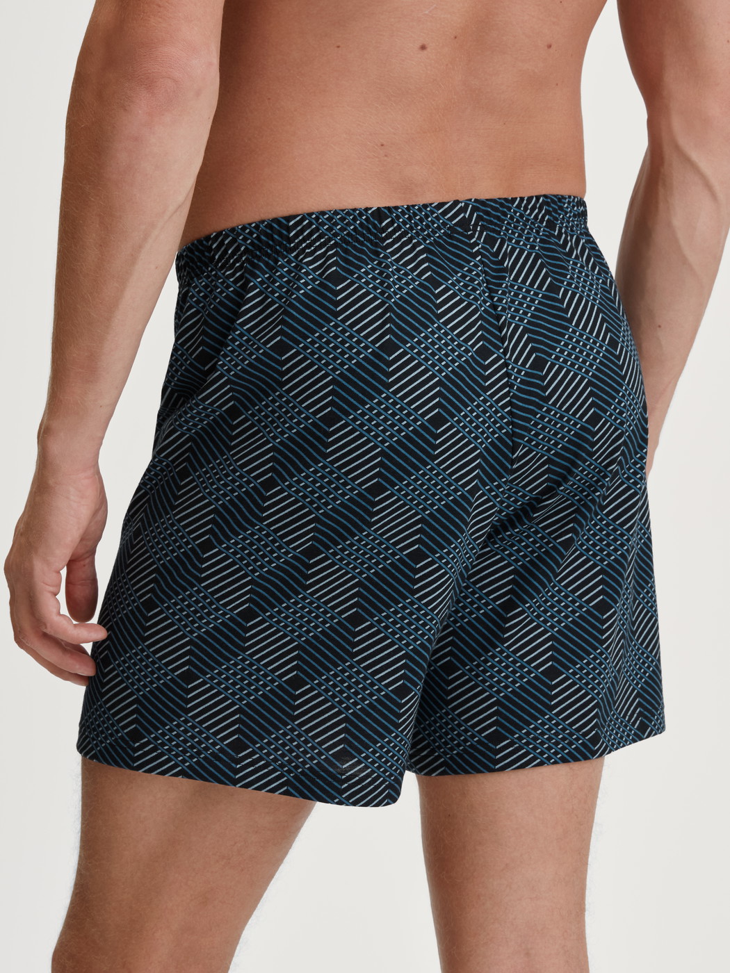 La modella / Il modello Uomo indossa Boxer short in 100% cotone di colore Nero, Modello, della serie Prints di CALIDA, Vista posteriore