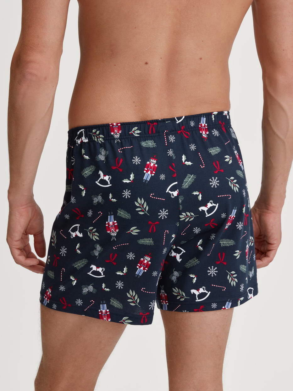 Herren-Model trägt Boxershorts aus 100% Baumwolle in Blau, Gemustert aus Serie Family & Friends von CALIDA, Rückansicht