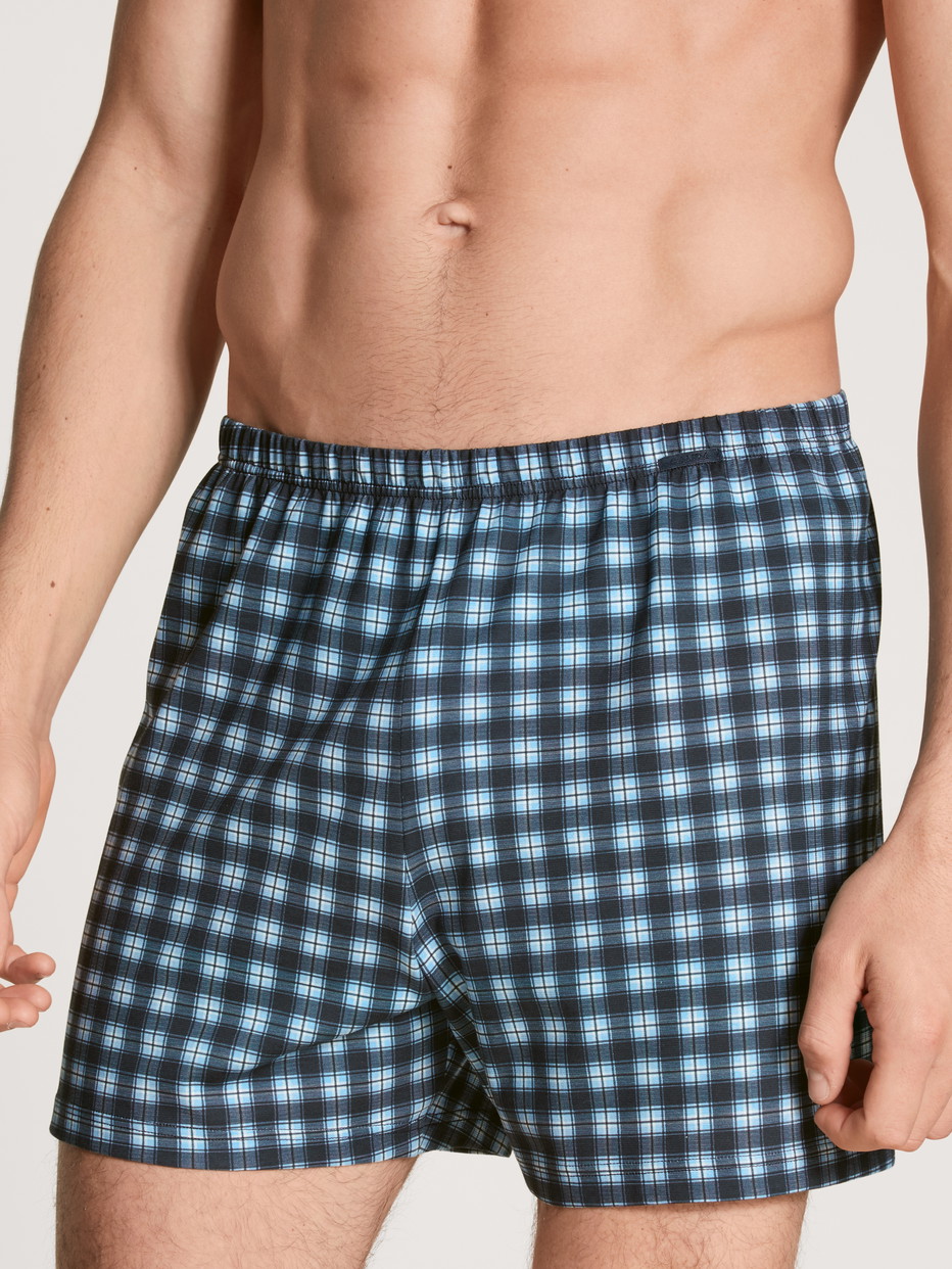 Herren-Model trägt Boxershorts, 2er-Pack aus 100% Baumwolle in Blau, Kariert aus Serie Prints Benefit von CALIDA, Vorderansicht