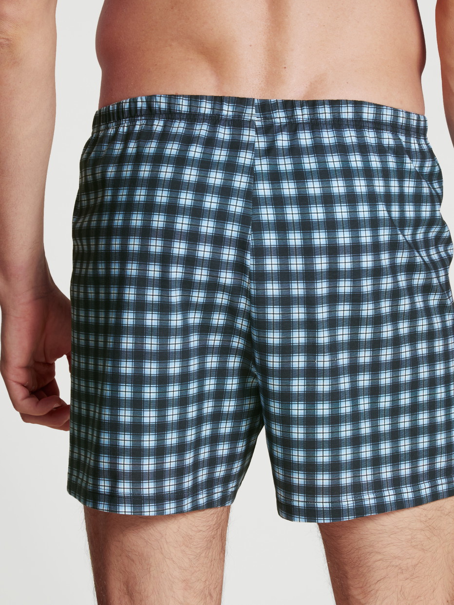 Herren-Model trägt Boxershorts, 2er-Pack aus 100% Baumwolle in Blau, Kariert aus Serie Prints Benefit von CALIDA, Rückansicht