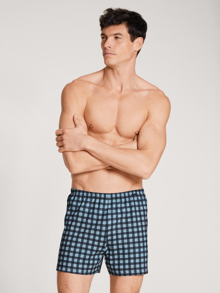 Herren-Model trägt Boxershorts, 2er-Pack aus 100% Baumwolle in Blau, Kariert aus Serie Prints Benefit von CALIDA, Vorderansicht