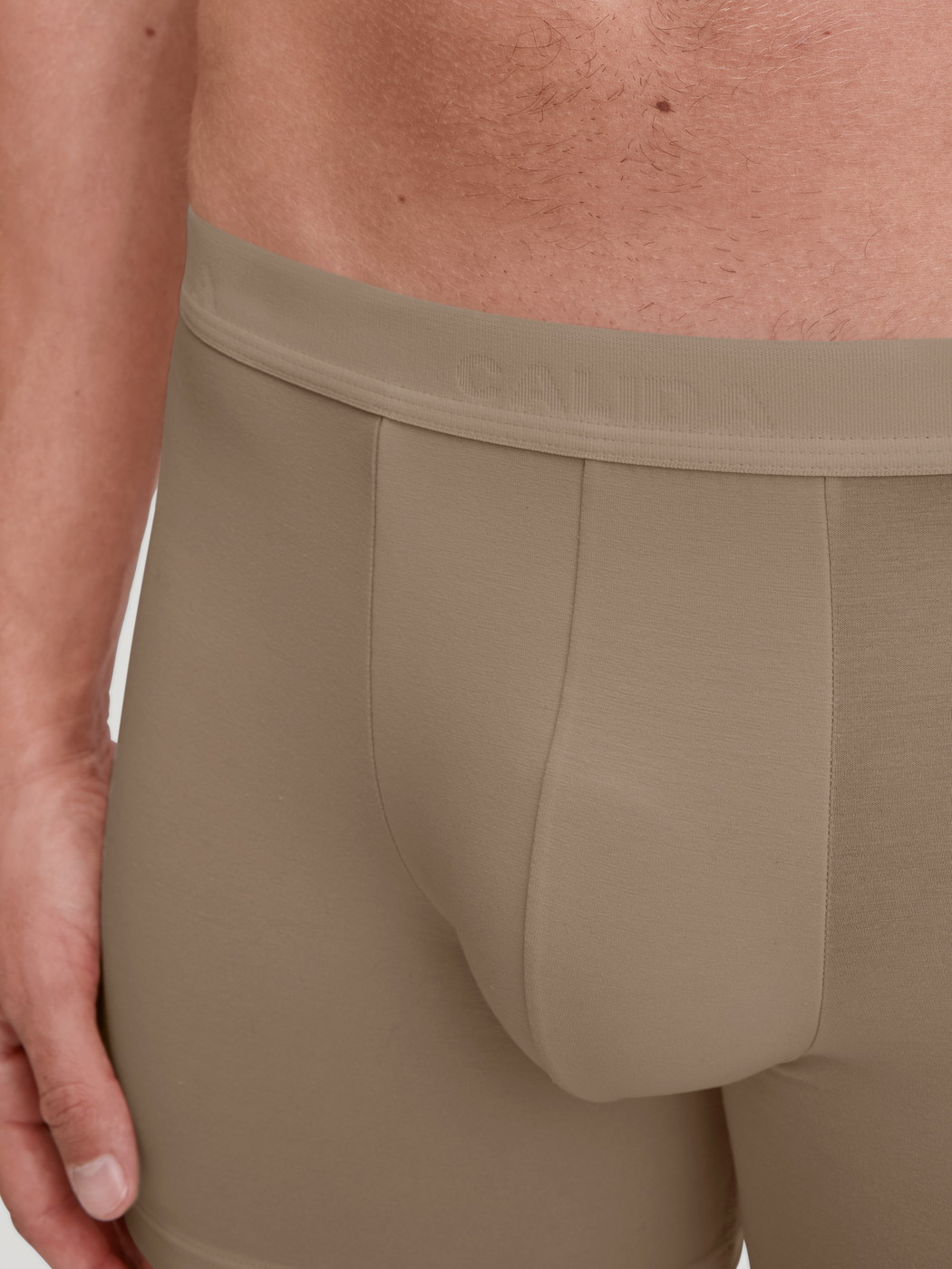 La modella / Il modello Uomo indossa Boxer lungo in TENCEL™ di colore Beige, Tinta unita, della serie Natural Cooling di CALIDA, Dettaglio