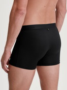 Men model is wearing Extended Boxer Briefs made of TENCEL™ in Black, Unicoloured from the Natural Cooling series by CALIDA, Back view