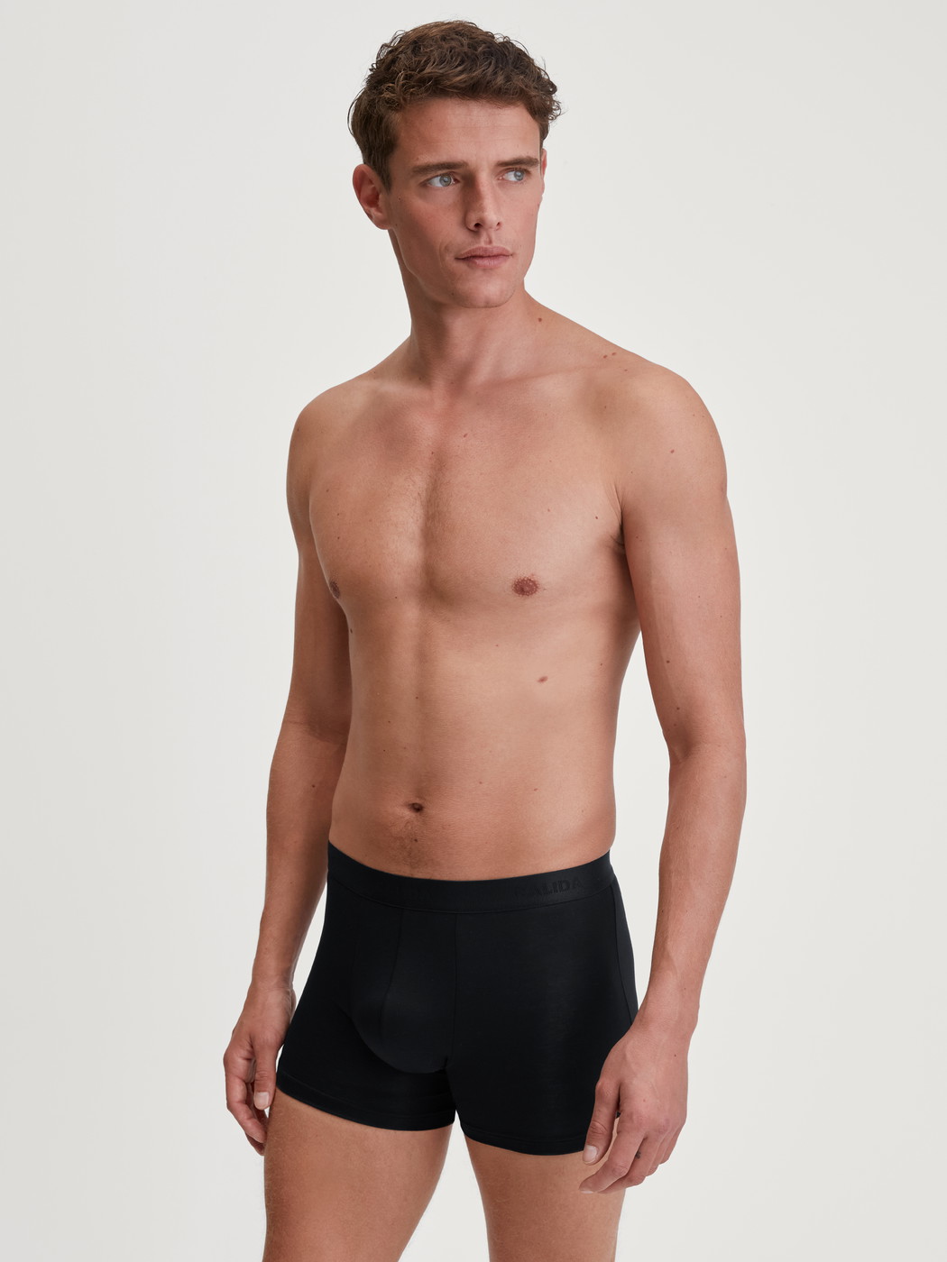 Men model is wearing Extended Boxer Briefs made of TENCEL™ in Black, Unicoloured from the Natural Cooling series by CALIDA, Outfit