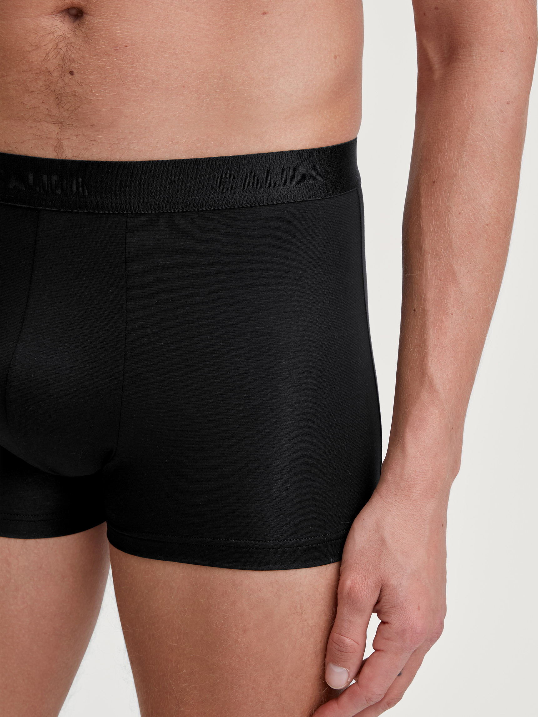 Herren-Model trägt Boxer Brief mit langem Bein aus TENCEL™ in Schwarz, Einfarbig aus Serie Natural Cooling von CALIDA, Detail