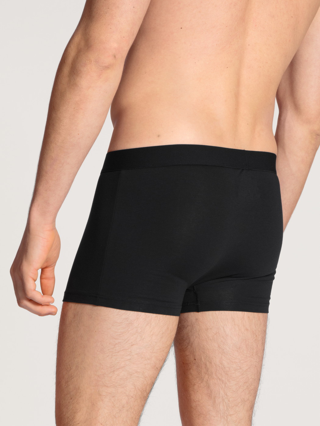 La modella / Il modello Uomo indossa Boxer brief in Cotone di colore Nero, Tinta unita, della serie Cotton Code di CALIDA, Vista posteriore